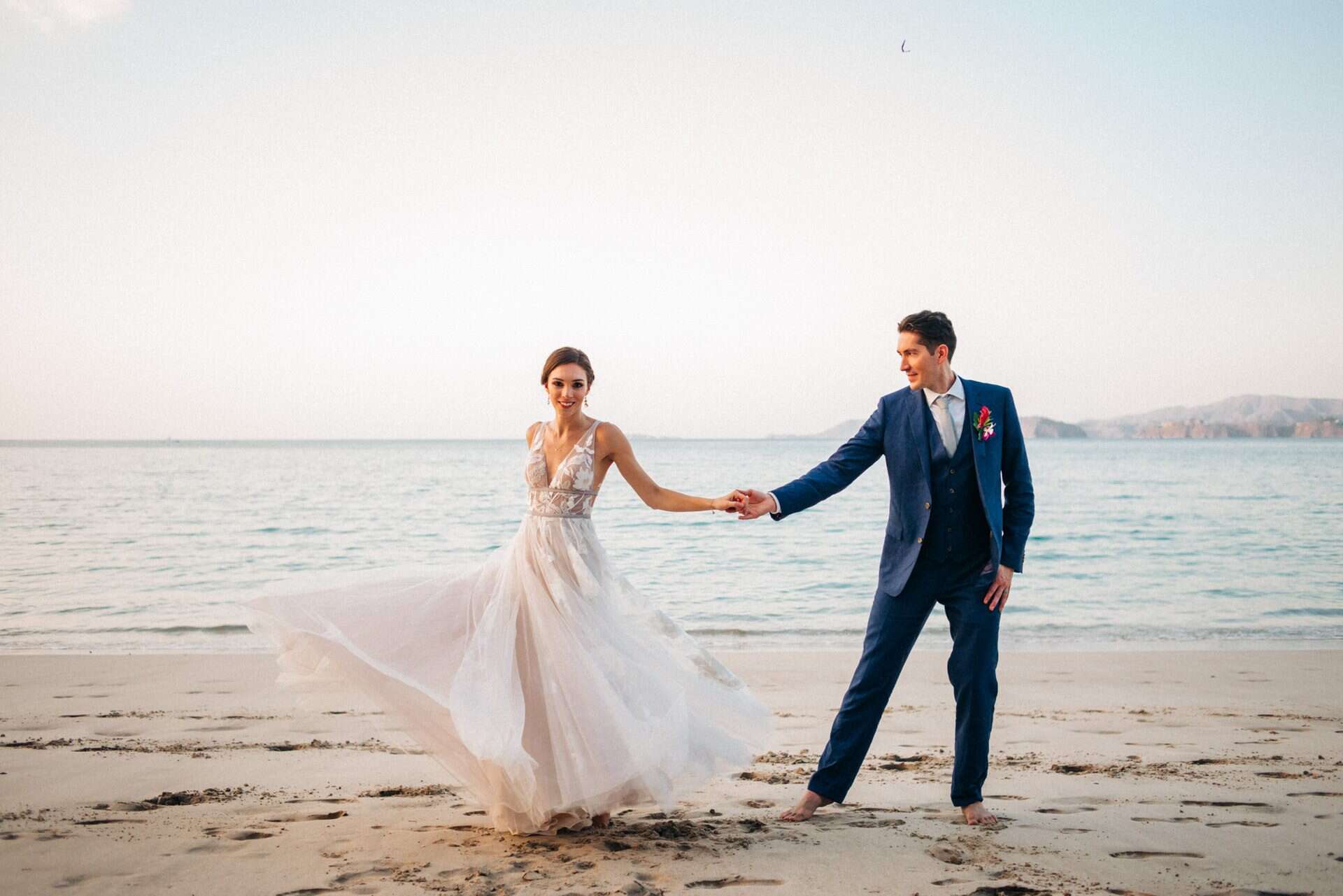 Bride and groom walking hand in hand on a Costa Rica beach after their wedding ceremony.