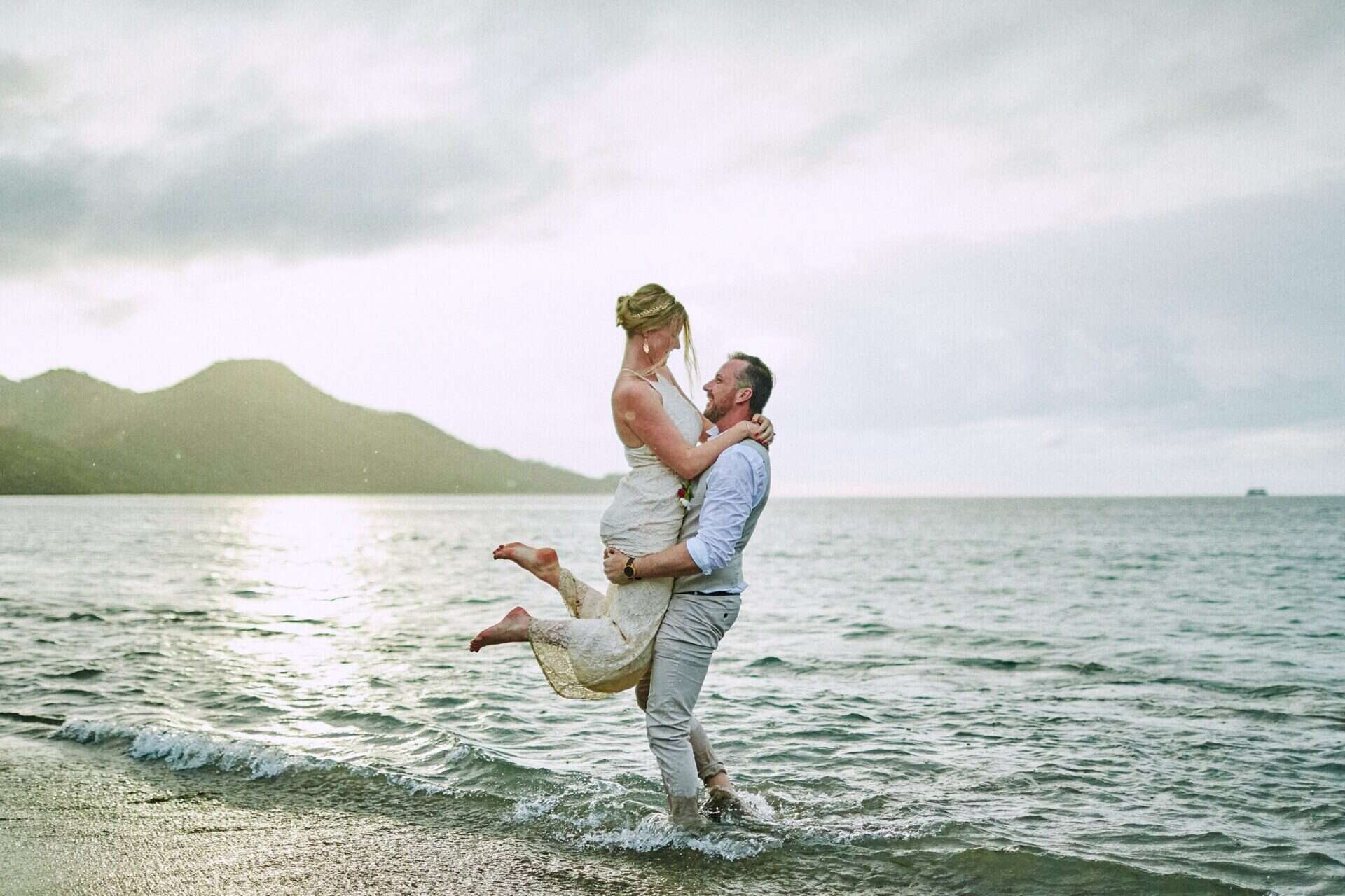 Bride and groom embracing in the ocean during sunset after their destination wedding in Costa Rica.