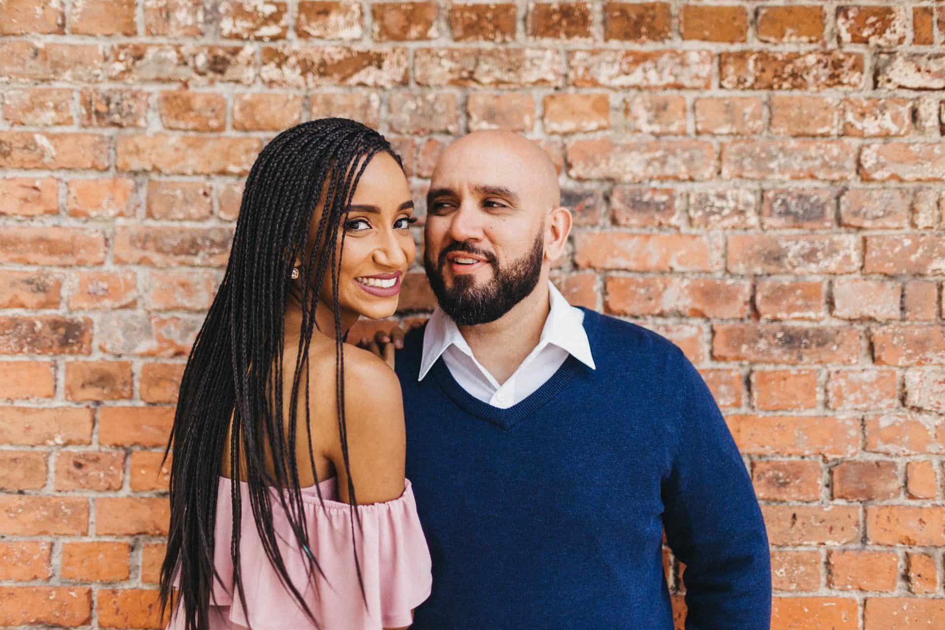 Candid moment of a couple walking hand in hand on a cobblestone street during their engagement session in Costa Rica.