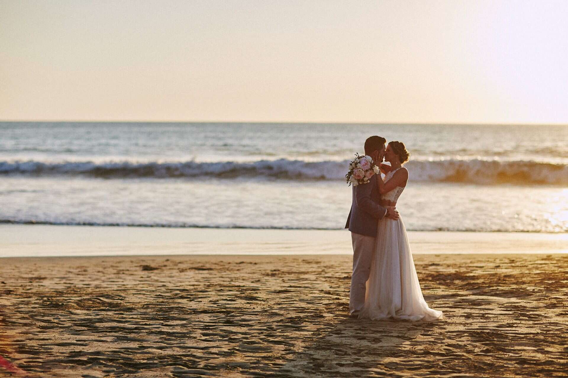 couple kissing at sunset wedding costa rica wedding guide January