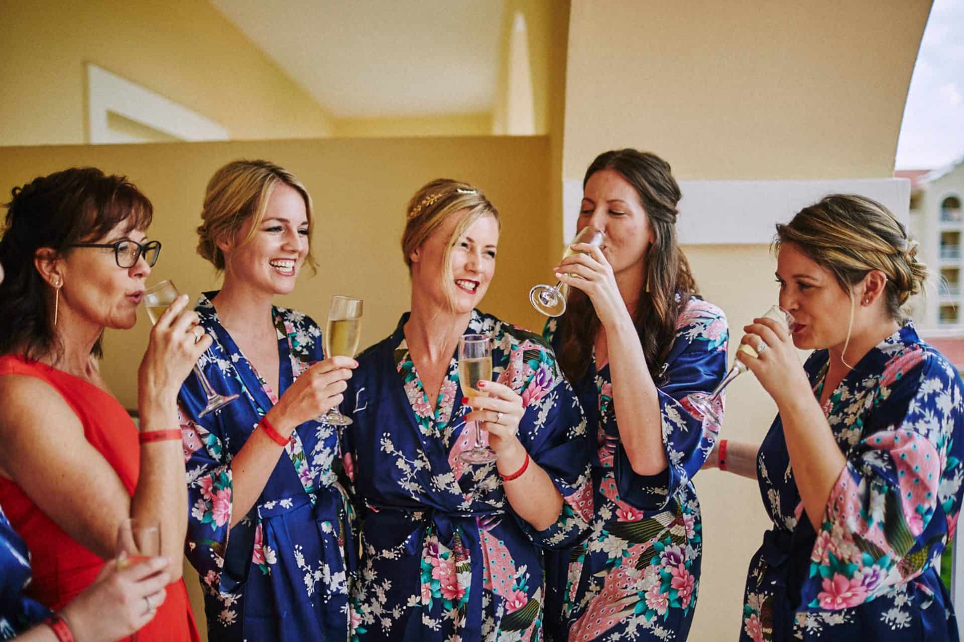bride and bridesmaids drinking champagne in costa rica wedding at Riu Palace