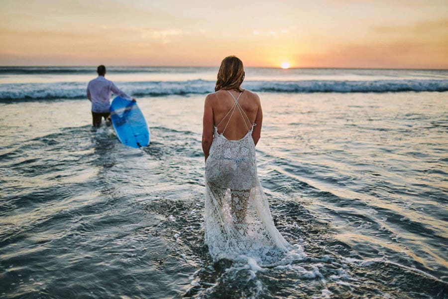 Bride walking into the ocean during an adventure elopement at Avellanas Beach, Costa Rica