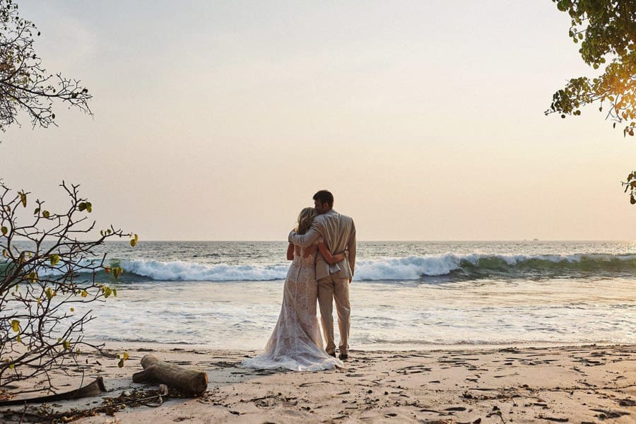 Alt<br />
Newlyweds embracing on Flamingo Beach during sunset in Costa Rica