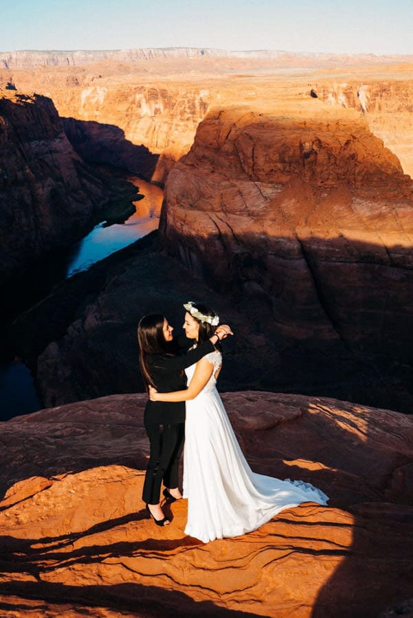 Two brides embracing during their elopement at Horseshoe Bend in Arizona