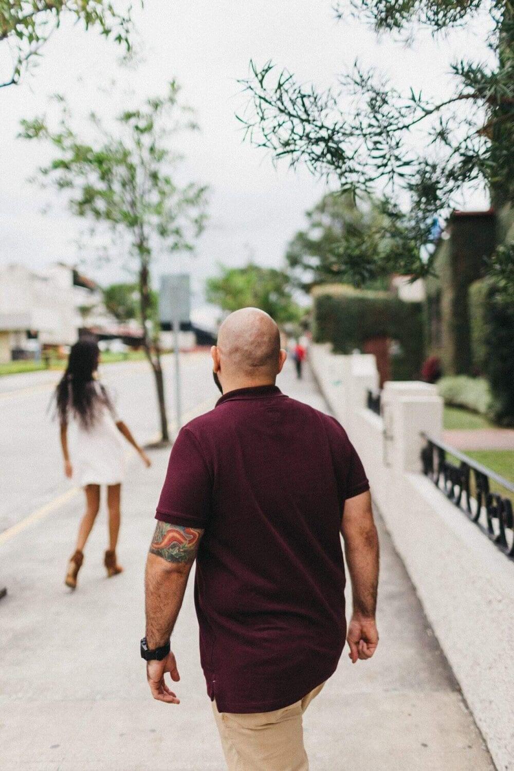 Couple posing in front of an old house in Costa Rica, blending cultural elements with their engagement session photography.