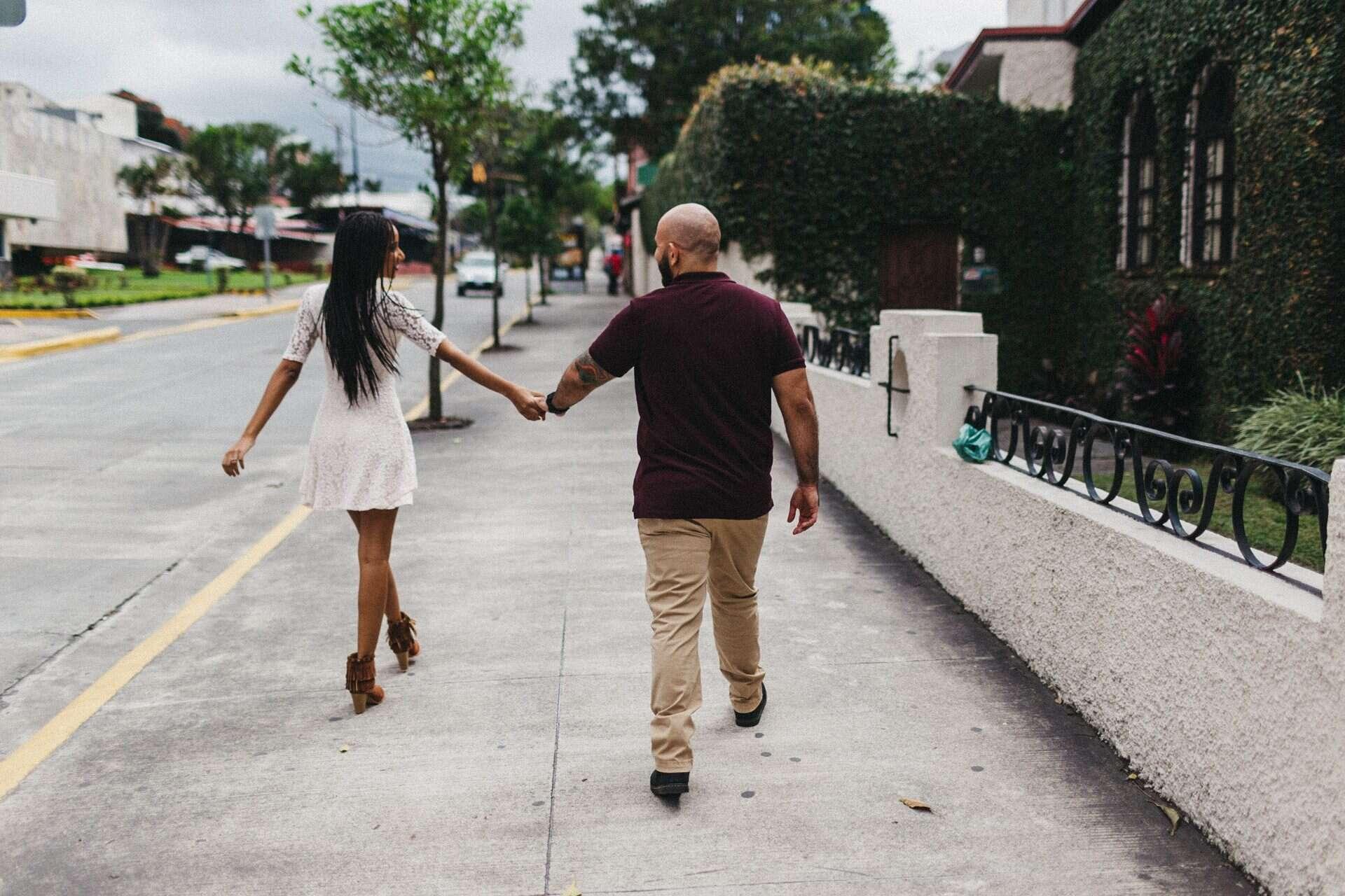 Couple posing in front of an old house in Costa Rica, blending cultural elements with their engagement session photography.