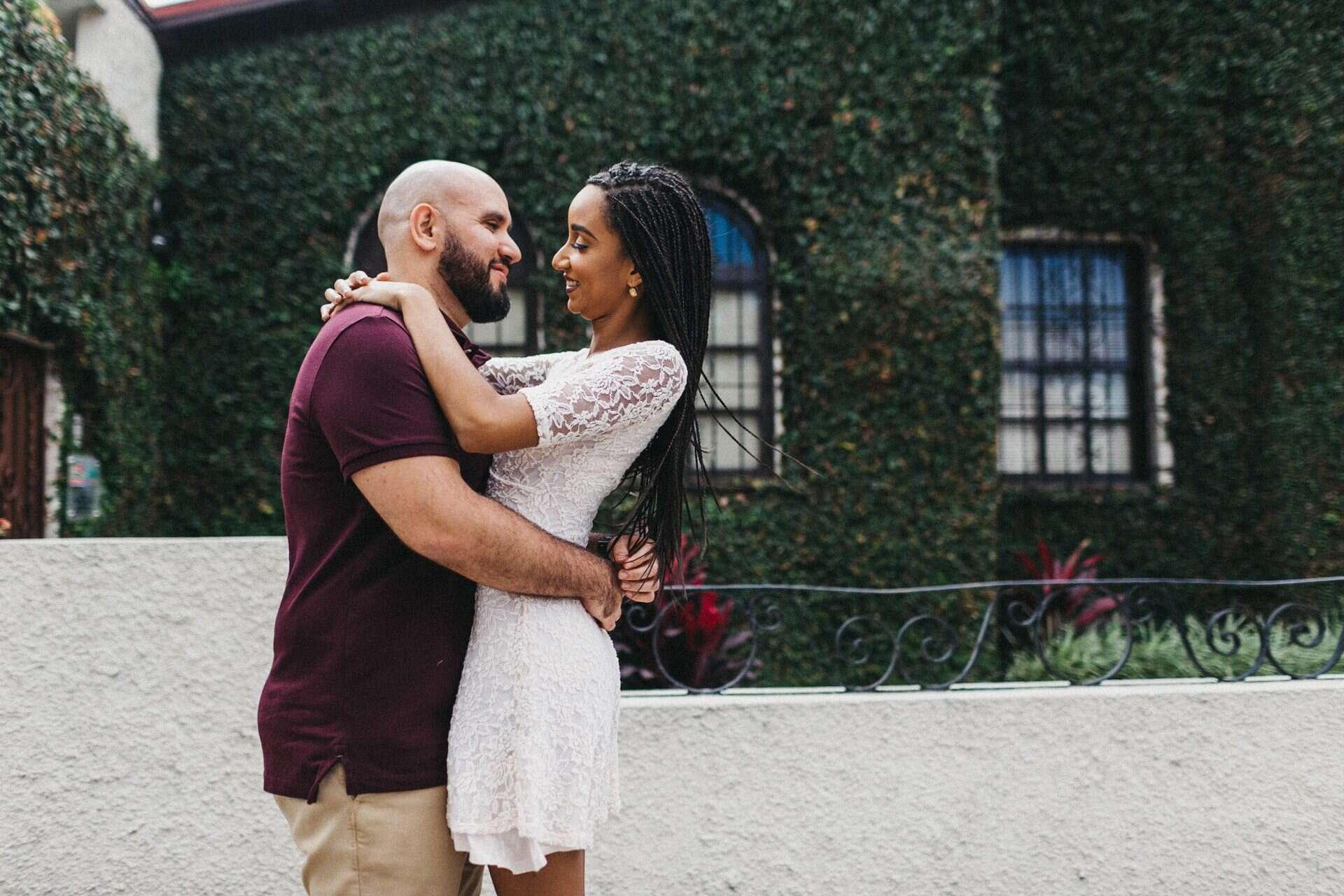 Couple posing in front of an old house in Costa Rica, blending cultural elements with their engagement session photography.