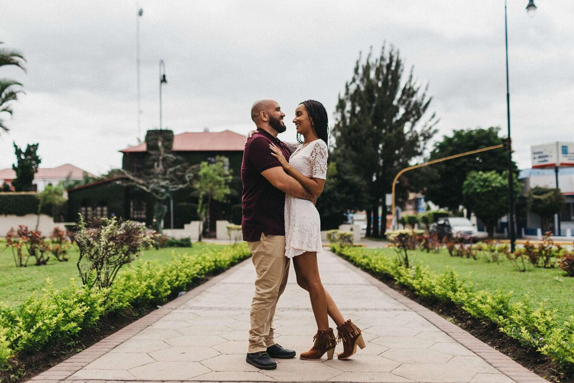 Couple enjoying a romantic engagement session in a historic neighborhood of San José, Costa Rica, surrounded by colorful colonial architecture.