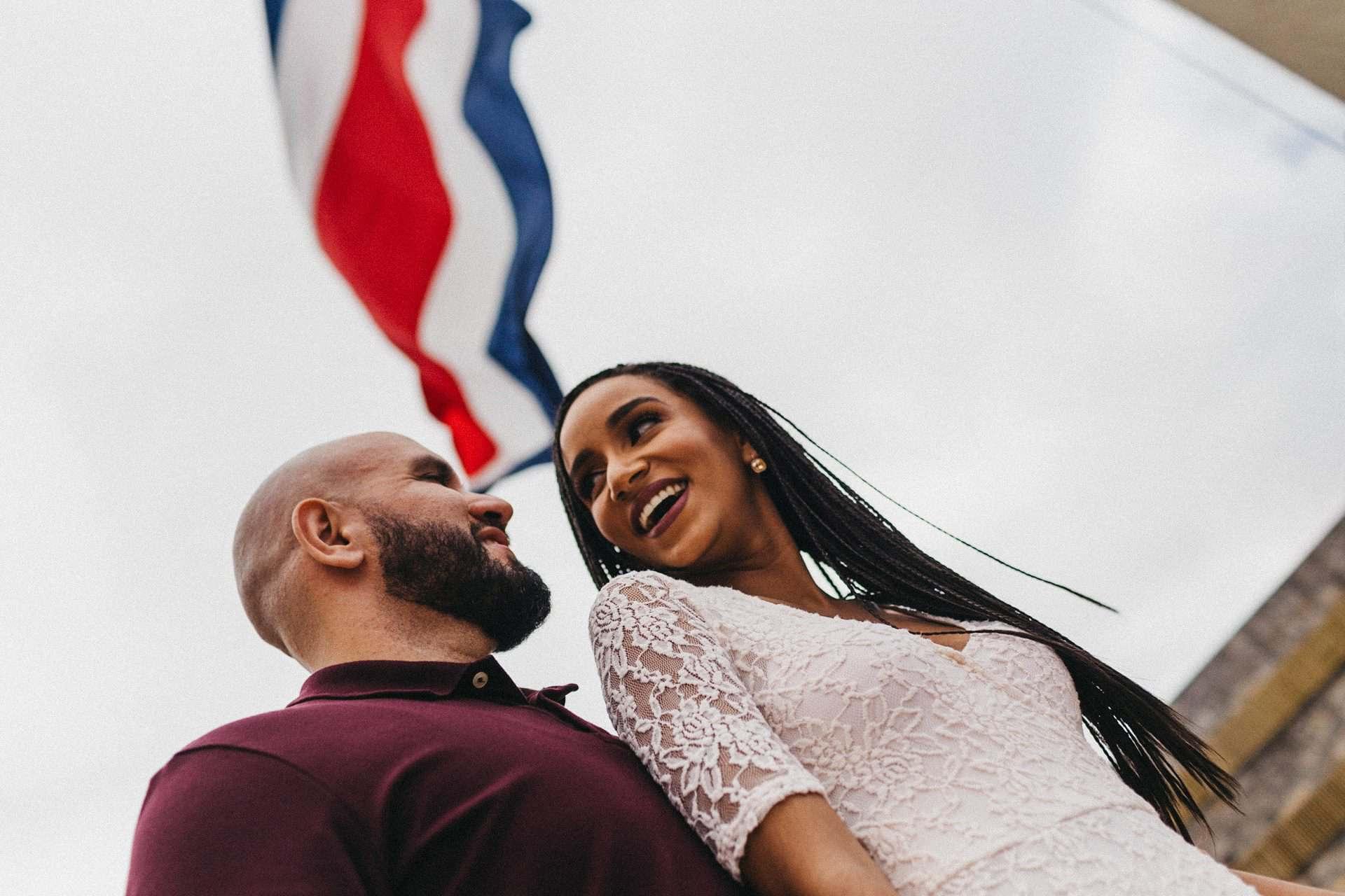 Couple dancing together on a quiet street in Costa Rica during their engagement session, captured in warm, golden afternoon light.